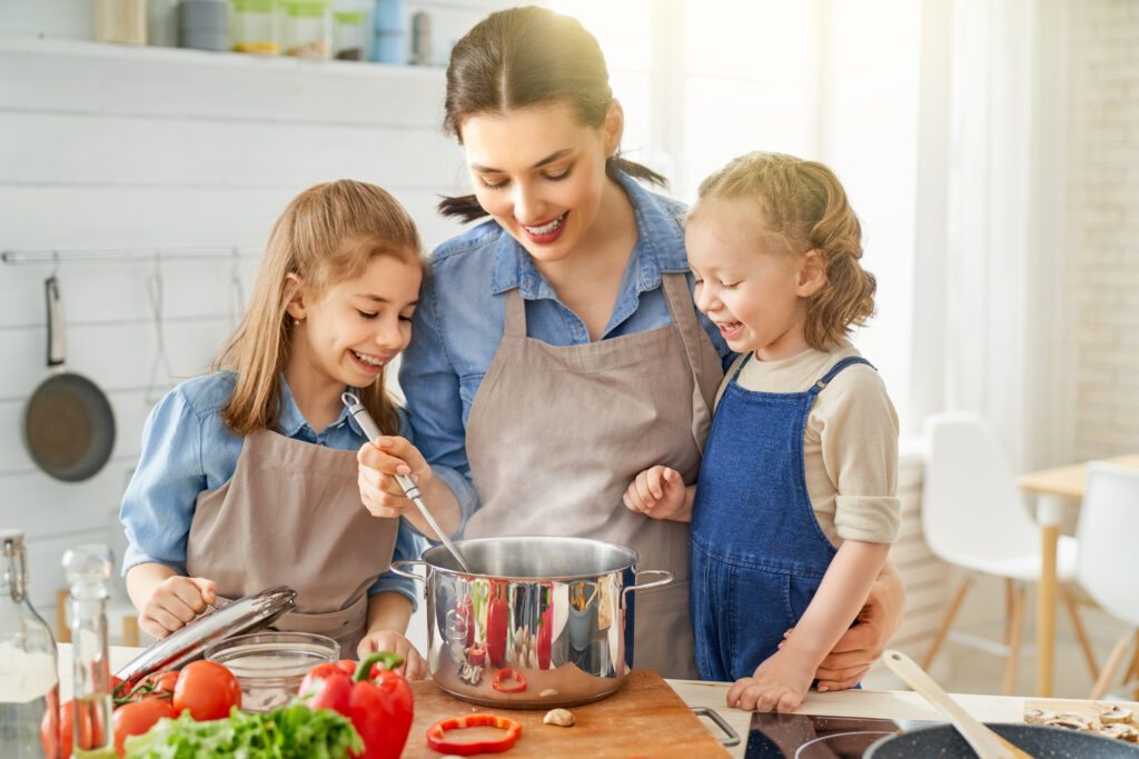 Familie fericită gătind împreună, subliniind importanța unei alimentații sănătoase pentru întărirea sistemului imunitar.